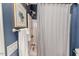 Cozy blue bathroom with shower and tub combination, white shower curtain, and artwork at 524 Auguston Ct, Sanford, NC 27330