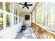 Inviting porch with wooden railing, rocking chair, and windows providing views of the wooded surroundings at 524 Auguston Ct, Sanford, NC 27330