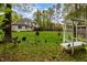 Large backyard features a well-manicured lawn, mature trees, and charming garden decor at 524 Birdsong Ln, Hurdle Mills, NC 27541