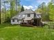 Large backyard featuring a deck, mature trees, and ample green space at 524 Birdsong Ln, Hurdle Mills, NC 27541