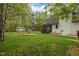 View of the backyard with a well-manicured lawn, a charming screened porch, and mature trees at 524 Birdsong Ln, Hurdle Mills, NC 27541