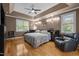 Comfortable primary bedroom with tray ceiling, hardwood floors, and plenty of natural light at 524 Birdsong Ln, Hurdle Mills, NC 27541