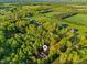 Lush, expansive aerial view of a home nestled amongst verdant trees and picturesque open fields at 580 Greenbriar Farm Trl, Siler City, NC 27344