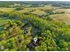 Expansive aerial view of estate with lush trees, a charming home, and sprawling green fields nearby at 580 Greenbriar Farm Trl, Siler City, NC 27344