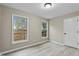 Bedroom with laminate floors, two windows with views, and a white paneled door at 580 Greenbriar Farm Trl, Siler City, NC 27344