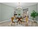 Stylish dining space with a glass table, comfortable seating, and an open view to the kitchen at 580 Greenbriar Farm Trl, Siler City, NC 27344