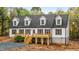 Charming home featuring a covered porch, white siding, a dark gray roof and meticulous landscaping at 580 Greenbriar Farm Trl, Siler City, NC 27344