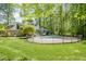 Expansive backyard view with a pool, gazebo, and verdant trees, enhancing the property's appeal at 5912 Weather Rock Ct, Raleigh, NC 27613