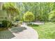 Lush backyard features a stone walkway, fountain, mature trees, and a fenced in pool at 5912 Weather Rock Ct, Raleigh, NC 27613