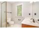 Clean bathroom with white vanity, white tile flooring, and natural light from the window above the toilet at 5912 Weather Rock Ct, Raleigh, NC 27613