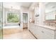 Luxurious bathroom with tub, dual vanity, and large window with natural light at 5912 Weather Rock Ct, Raleigh, NC 27613