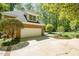 Spacious two-car garage with brick exterior and manicured landscaping leading to a pool area at 5912 Weather Rock Ct, Raleigh, NC 27613