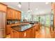 Well-appointed kitchen with a central island, stainless appliances, granite countertops, and wood cabinetry at 5912 Weather Rock Ct, Raleigh, NC 27613