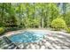 Inviting in-ground pool with a spacious sun deck, surrounded by a wrought iron fence and green trees at 5912 Weather Rock Ct, Raleigh, NC 27613