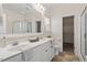 Bright bathroom with double sinks, large mirror, and a shower featuring glass doors at 632 Hunters Ridge Dr, Fuquay Varina, NC 27526