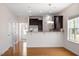 Open-concept kitchen with breakfast bar, stainless steel refrigerator, and hardwood floors at 632 Hunters Ridge Dr, Fuquay Varina, NC 27526