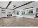 Open-concept living space with a fireplace, modern ceiling fan, and views into the kitchen at 66 Privette Way, Zebulon, NC 27597