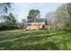 Expansive backyard showing lawn, the house, mature trees and the surrounding neighborhood at 704 N King Charles Rd, Raleigh, NC 27610