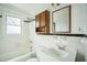 Bathroom featuring classic tile, a wood cabinet, and a window for natural light at 704 N King Charles Rd, Raleigh, NC 27610