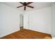 Bedroom with hardwood floors, white walls, closet, and easy access to other rooms at 704 N King Charles Rd, Raleigh, NC 27610