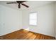 Bedroom with hardwood floors, white walls, a ceiling fan, and closet at 704 N King Charles Rd, Raleigh, NC 27610