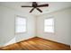 Bedroom with hardwood floors, white walls, a ceiling fan, and natural light at 704 N King Charles Rd, Raleigh, NC 27610