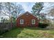Side-rear angle of red brick house with a gabled roof and side yard at 704 N King Charles Rd, Raleigh, NC 27610