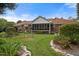 Tranquil backyard with manicured gardens, a screened porch, and stone-lined flowerbeds, enhancing curb appeal at 705 N Gurney St, Burlington, NC 27215