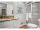 This bathroom offers a granite counter and a shower with glass doors and white cabinets for storage at 705 N Gurney St, Burlington, NC 27215