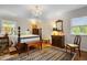 Serene bedroom featuring a four-poster bed, chandelier, and hardwood floors at 705 N Gurney St, Burlington, NC 27215