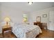This bedroom has hardwood floors, a comfortable bed with side tables and lamps, and a wooden desk with mirror at 705 N Gurney St, Burlington, NC 27215