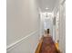 A hallway features a red patterned rug, hardwood floors and white trim at 705 N Gurney St, Burlington, NC 27215