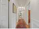 The hallway leads to the various rooms with hardwood floors and white walls at 705 N Gurney St, Burlington, NC 27215