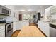 Spacious kitchen with white cabinets, granite countertops, and hardwood floors, adjacent to breakfast nook at 705 N Gurney St, Burlington, NC 27215