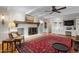 Cozy living room with brick fireplace, beamed ceiling, built-in shelves, and a plush red rug at 705 N Gurney St, Burlington, NC 27215