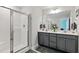 Modern bathroom with a double vanity, a large mirror, and walk-in glass shower at 713 Putney Hill Rd, Zebulon, NC 27597