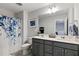 Well-appointed bathroom with a double vanity, stylish shower curtain, and modern fixtures at 713 Putney Hill Rd, Zebulon, NC 27597