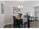 Cozy dining room features a wooden table, four chairs, and elegant chandelier lighting at 713 Putney Hill Rd, Zebulon, NC 27597