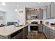 Modern kitchen with granite countertops, stainless steel appliances, and stylish gray cabinetry at 713 Putney Hill Rd, Zebulon, NC 27597
