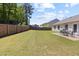 Spacious backyard with a well-maintained lawn, wooden fence, and patio area, perfect for outdoor entertaining at 729 Golden Horseshoe Ln, Sanford, NC 27330