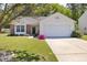 Charming home with brick accents, a well-manicured lawn, and a driveway leading to a two-car garage at 729 Golden Horseshoe Ln, Sanford, NC 27330