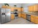 Modern kitchen features stainless steel appliances, oak cabinets, and tile backsplash at 729 Golden Horseshoe Ln, Sanford, NC 27330