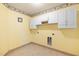 Bright laundry room with tile floors, white cabinets, and decorative wallpaper border at 729 Golden Horseshoe Ln, Sanford, NC 27330