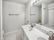Well-lit bathroom with double vanity sinks, large mirror, modern fixtures, and tub with shower at 7425 Silver View Ln, Raleigh, NC 27613
