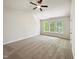 Spacious bedroom featuring carpet, large windows that provide ample natural light, and a ceiling fan at 7425 Silver View Ln, Raleigh, NC 27613
