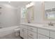 Bright bathroom featuring double vanities, white cabinets, and tiled walls over a soaking tub at 811 Fargo St, Durham, NC 27707