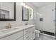 Bathroom includes double sinks, granite countertops, modern lighting, a shower, and a window at 811 Fargo St, Durham, NC 27707