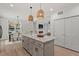 Open floor plan with kitchen island, pendant lighting, and stainless steel appliances overlooks dining and living areas at 811 Fargo St, Durham, NC 27707