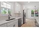Bright kitchen features stainless steel appliances, a sink with modern faucet, and two windows at 811 Fargo St, Durham, NC 27707