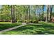 Beautiful backyard with mature trees, walkway, landscaping and sunny green lawn at 85 Rivers Edge Ct, Timberlake, NC 27583